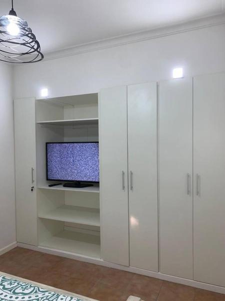 sala de estar con armarios blancos y Tv LED en Casona centrica alameda Mendoza en Mendoza