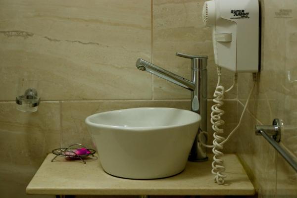y baño con secador de pelo y lavamanos. en Hosteria Dalmacia en Pinamar