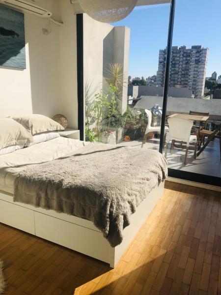 1 dormitorio con cama y ventana grande en Cozy and sunny apartment in the saavedra neighborhood en Buenos Aires