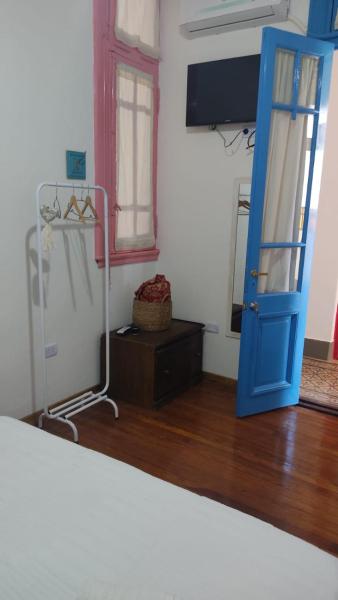 Habitación con puerta azul y espejo. en Aristobulo en Buenos Aires