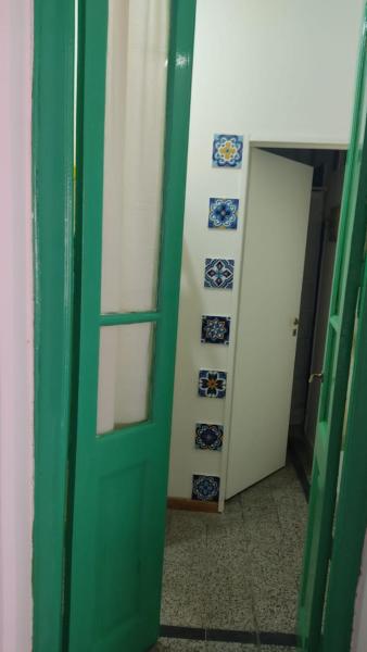 una puerta verde en una habitación con placas azules y blancas en Aristobulo en Buenos Aires
