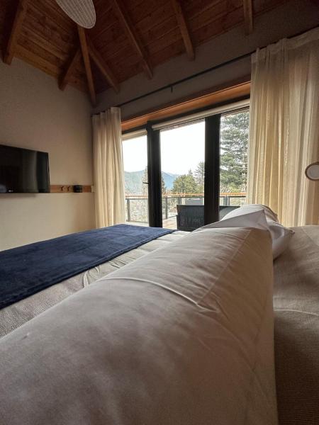 1 dormitorio con cama grande y ventana grande en TERRAZAS DEL MASCARDI - LUXURY APARTMENT - INMEJORABLE UBICACION en San Martín de los Andes