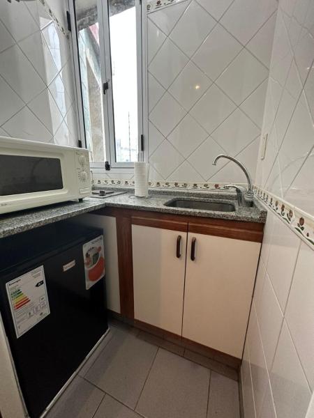 una pequeña cocina con fregadero y microondas en Departamento Monoambiente en Microcentro Buenos Aires Obelisco en Buenos Aires