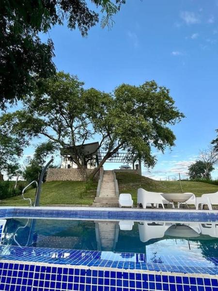 una piscina con sillas blancas y una mesa en Casa Quincho ROMA en Salta