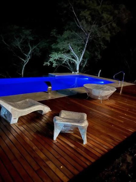 terraza de madera con 2 mesas y bañera en Casa Quincho ROMA en Salta