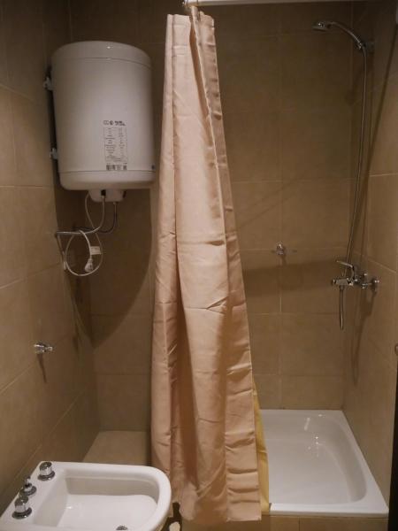 y baño con cortina de ducha, aseo y lavamanos. en Habitación Privada en Edificio de Departamentos en Salta