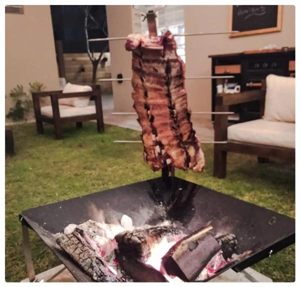 un trozo de carne está siendo cocinado en una parrilla en Complejo Villa Calitri en Villa Gesell