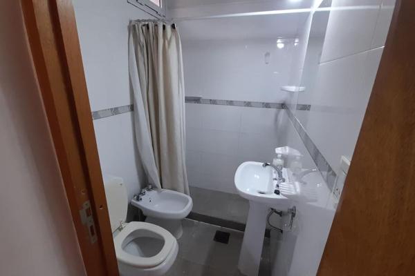 Baño blanco con aseo y lavamanos en Hermoso loft en Barrio Bombal en Mendoza