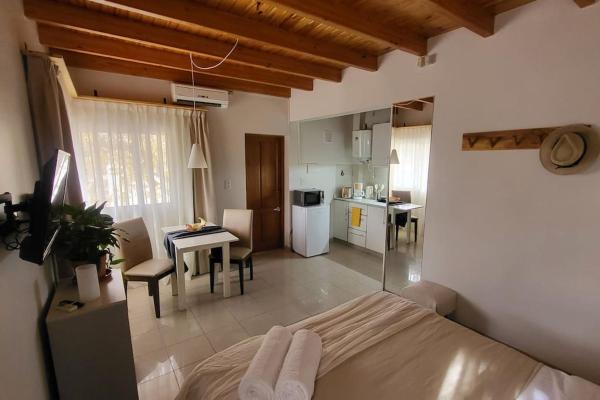 1 dormitorio con 1 cama y cocina con mesa en Hermoso loft en Barrio Bombal en Mendoza