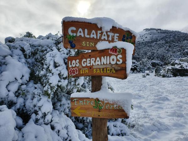 un cartel cubierto de nieve junto a los arbustos nevados en Entre Verdes en San Martín de los Andes