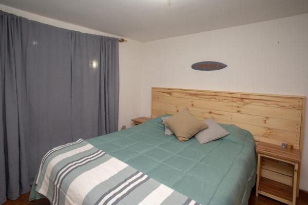 1 dormitorio con 1 cama con cabecero de madera en 1331 House en San Martín de los Andes