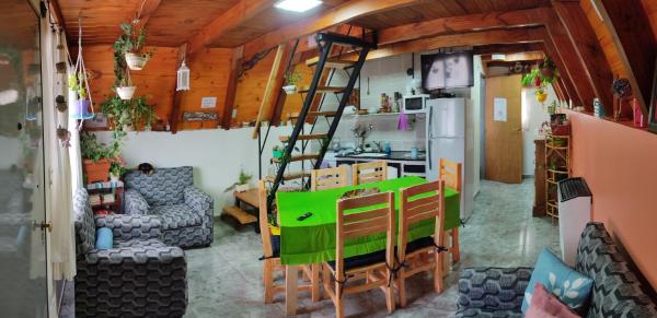 una sala de estar con una mesa verde y una escalera en Paluna cabaña en San Martín de los Andes