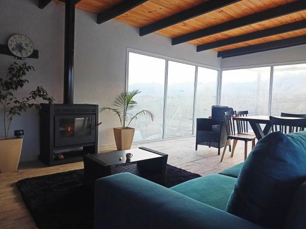 sala de estar con sofá azul y chimenea en Crucecita Eco Lodge en Mendoza