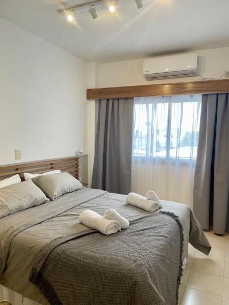 1 dormitorio con 2 toallas en una cama con ventana en Impecable Depto Centro Salta! en Salta