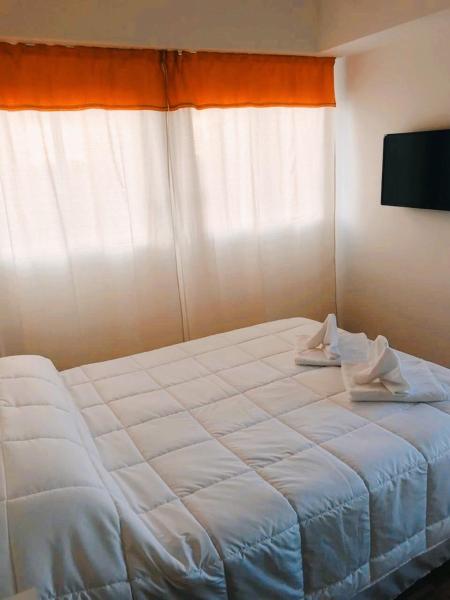 1 dormitorio con 1 cama blanca y 2 toallas en EC Apartments en Buenos Aires