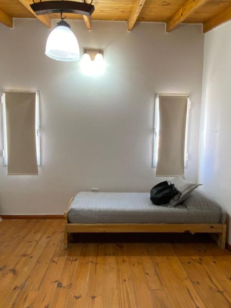 Un dormitorio con una cama con una mochila. en La alegre! Hermosa casa centrica y cerca del mar en Puerto Madryn