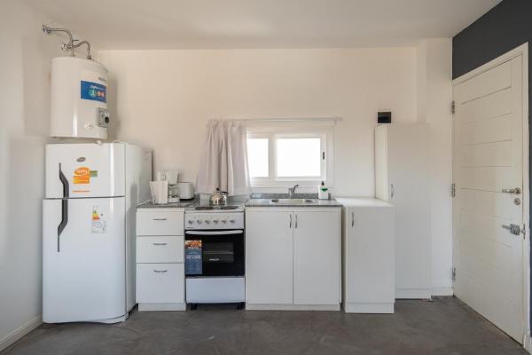 cocina blanca con electrodomésticos blancos y ventana en Divino mono ambiente en el centro de Pinamar, cerca de todo en Pinamar