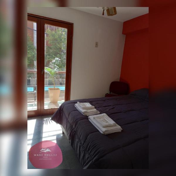 1 dormitorio con 1 cama con toallas en Wasi Melliz en San Salvador de Jujuy