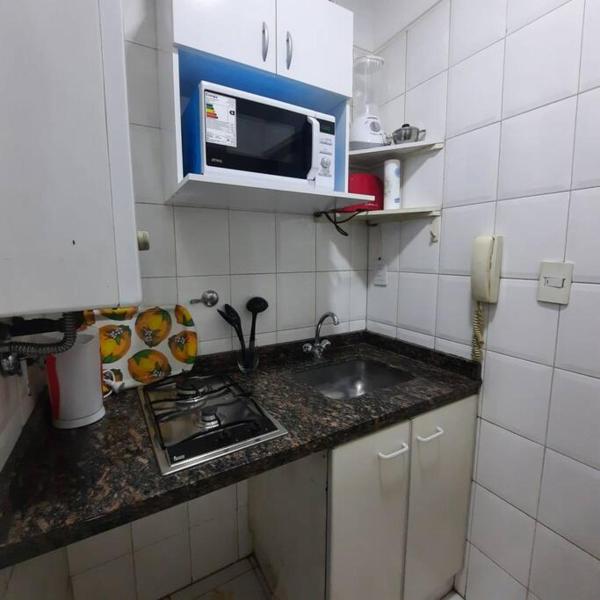 una pequeña cocina con fregadero y microondas en Departamento Plaza España con cochera en Mendoza