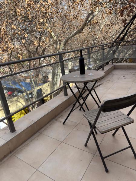 una mesa y una botella de vino en el balcón en Depto Malbec calle Cordoba en Mendoza