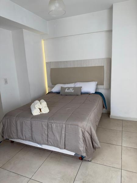 1 dormitorio con 1 cama con 2 toallas en Depto Malbec calle Cordoba en Mendoza