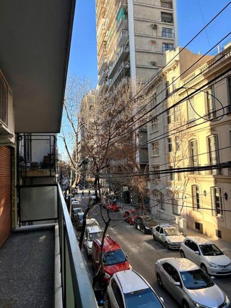 Vistas a una calle de la ciudad con coches y edificios aparcados en Grand apartment in Recoleta en Buenos Aires