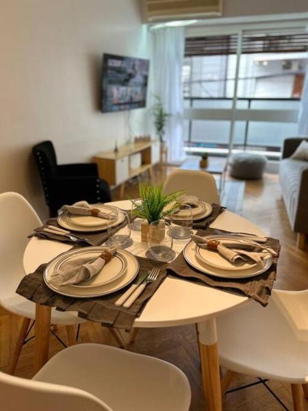 una mesa con platos y cubiertos. en Grand apartment in Recoleta en Buenos Aires