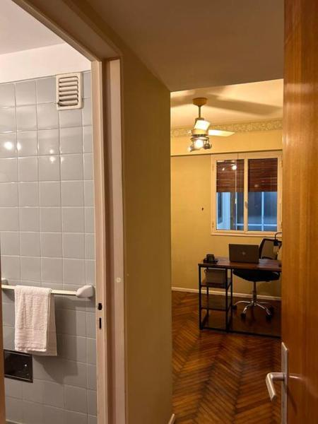 baño con ducha y escritorio con ordenador portátil. en Grand apartment in Recoleta en Buenos Aires