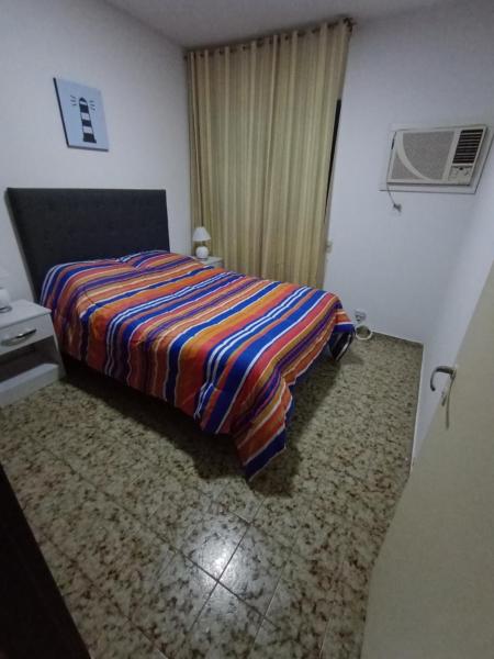 Un dormitorio con una cama con una manta de colores. en Depto 4-6 Personas en San Juan