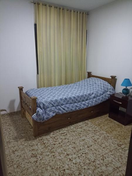 1 dormitorio con 1 cama con edredón azul en Depto 4-6 Personas en San Juan