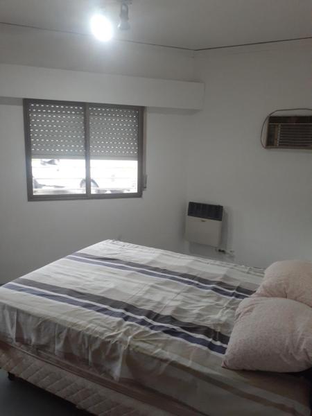 1 dormitorio con 1 cama grande y ventana en Casa centrica gualeguaychu 2 en Gualeguaychú