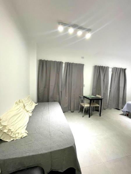 Un dormitorio con una cama y una mesa. en Latorre Apartment en Salta