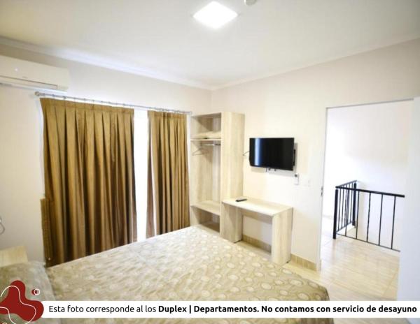 1 dormitorio con 1 cama y TV en una habitación en Z Hotel Boutique en Puerto Iguazú