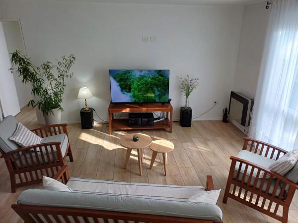 sala de estar con sofá y Tv LED en Ventanas de la Patagonia en Esquel