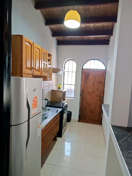 cocina con refrigerador y armarios de madera en La Ituzaingó en Mendoza