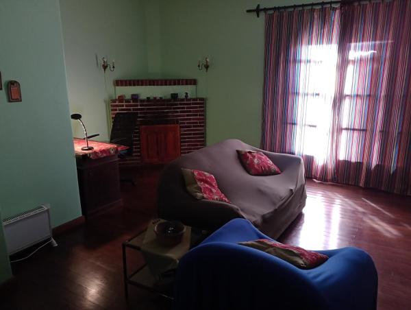 sala de estar con sofá y chimenea en La Casa Verde en San Salvador de Jujuy