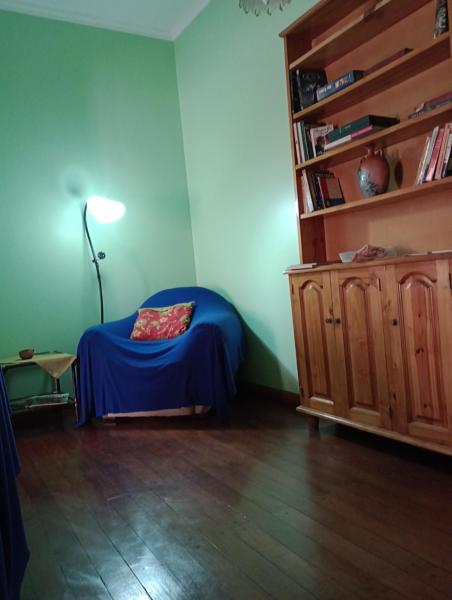 Habitación con cama y estante para libros en La Casa Verde en San Salvador de Jujuy