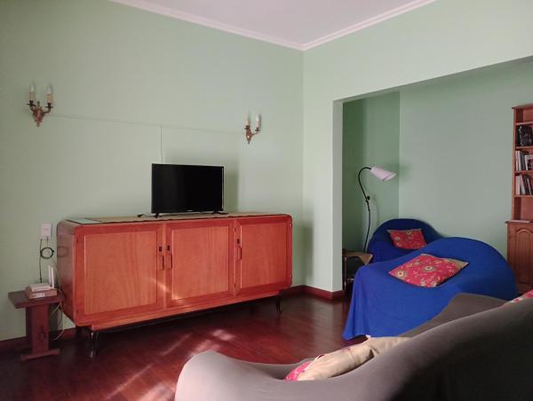 sala de estar con TV y sofá en La Casa Verde en San Salvador de Jujuy