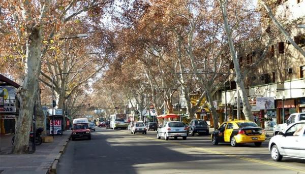 una concurrida calle de la ciudad con coches aparcados en la carretera en Dpto. 25 de Mayo y Las Heras en Mendoza