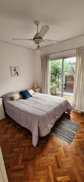 1 dormitorio con 1 cama grande y ventilador de techo en Kelly House en Mendoza