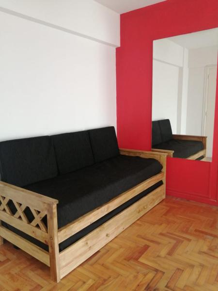 un sofá en una habitación con una pared roja y blanca en Depto. 2 ambientes luminoso Villa Crespo - cerca del Movistar Arena en Buenos Aires