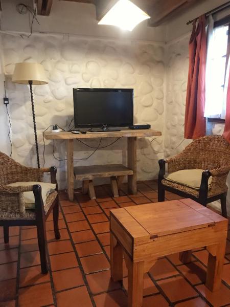 sala de estar con TV, mesa y sillas en Casa Mora en San Martín de los Andes