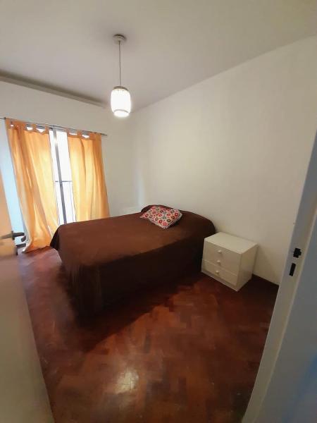 1 dormitorio con cama marrón y ventana en DEPARTAMENTO PLENO CENTRO en Mendoza