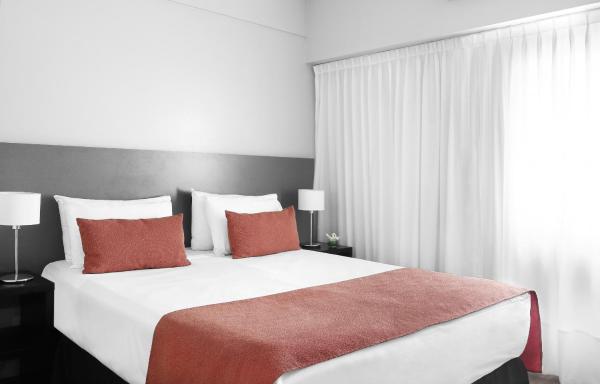 1 dormitorio con 1 cama blanca grande con almohadas rojas en Departamento ubicado en Recoleta ideal para familias en Buenos Aires