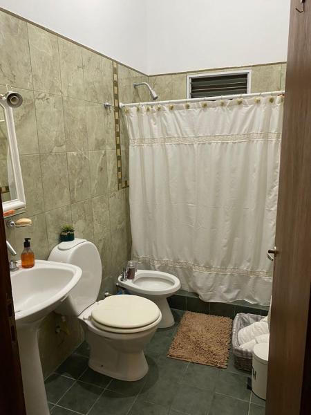 y baño con aseo, lavabo y ducha. en La escondida departamento en Salta