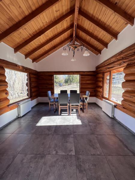 comedor con paredes de madera, mesa y sillas en Villa Soñada - Encantadora Casa para 6 Personas en Esquel