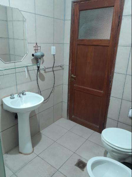 baño con lavabo, aseo y puerta en departamento Gorriti en San Salvador de Jujuy