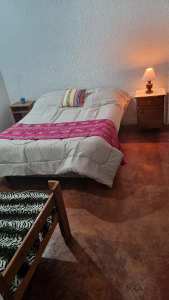 1 cama en una habitación con una lámpara en una mesa en Casa Norte en Salta