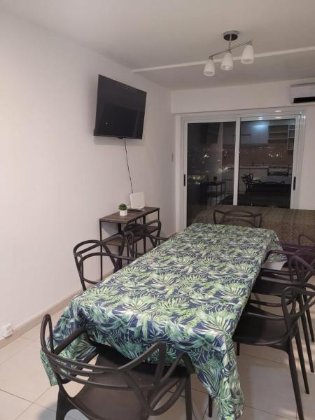 comedor con mesa, sillas y TV en Departamento Calle Cordoba en San Miguel de Tucumán