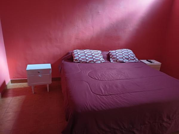 Cama pequeña en habitación con pared roja en Lo de ines en Salta